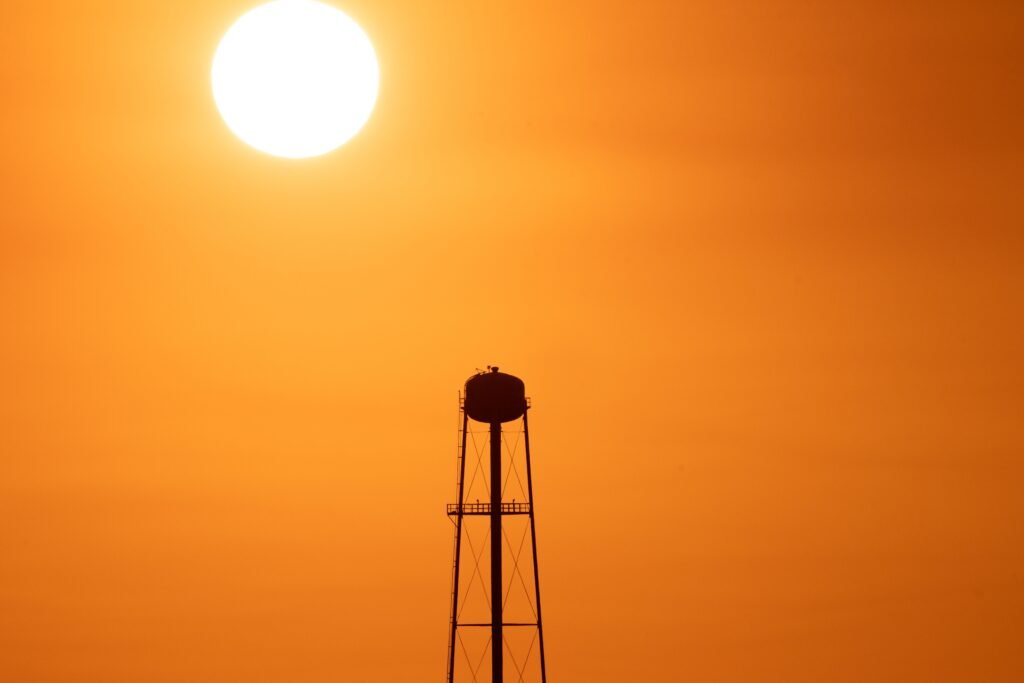 Summer Time A striking sunset silhouette of a water tower against a vivid orange sky in Mather, CA.